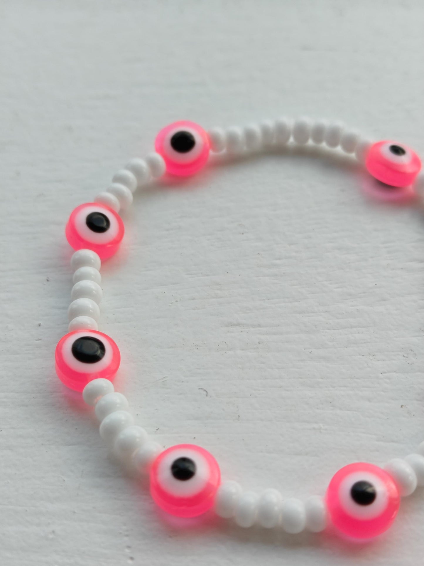 Evil eye inspired pink charm and seed bead bracelet