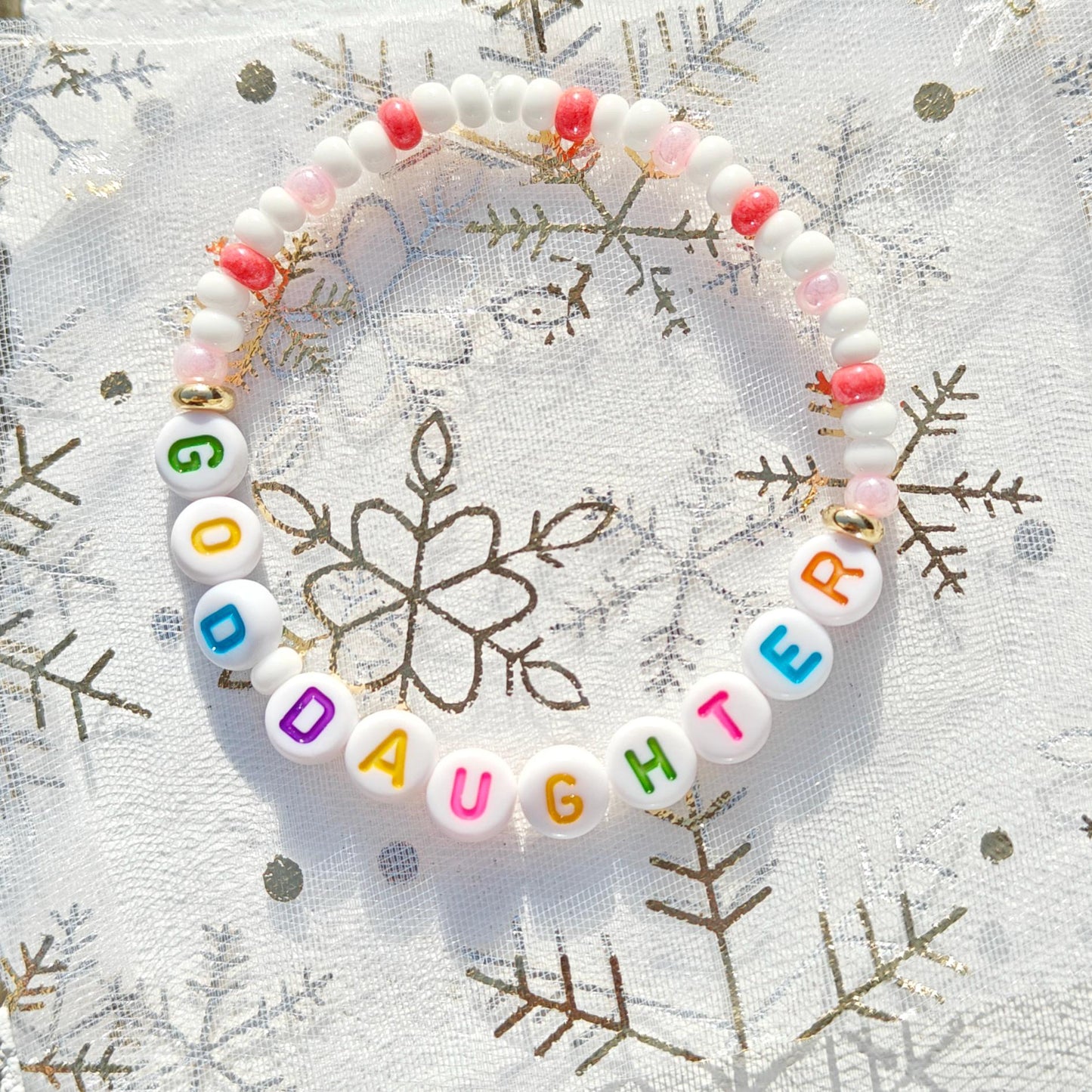 Colorful personalized name bead bracelet in pink white and gold with multicolored acrylic letter beads