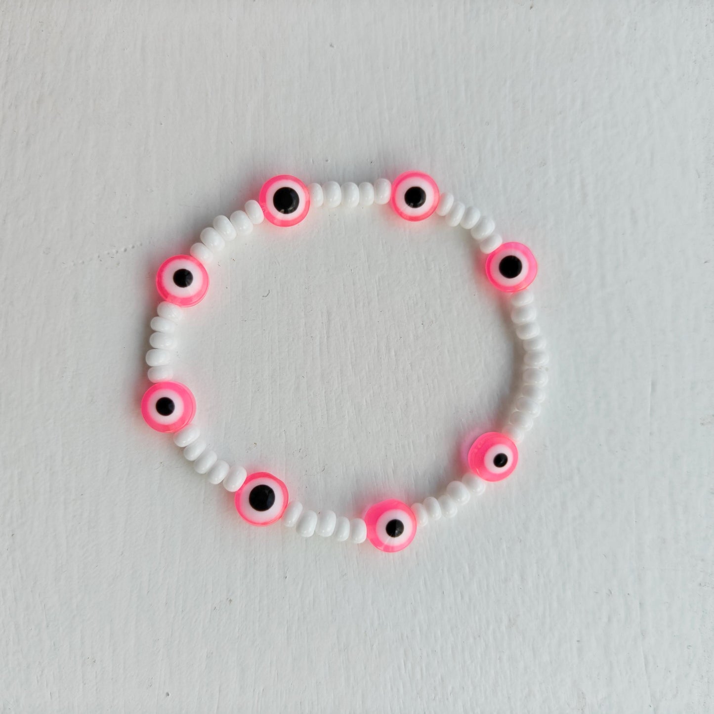 Evil eye inspired pink charm and seed bead bracelet