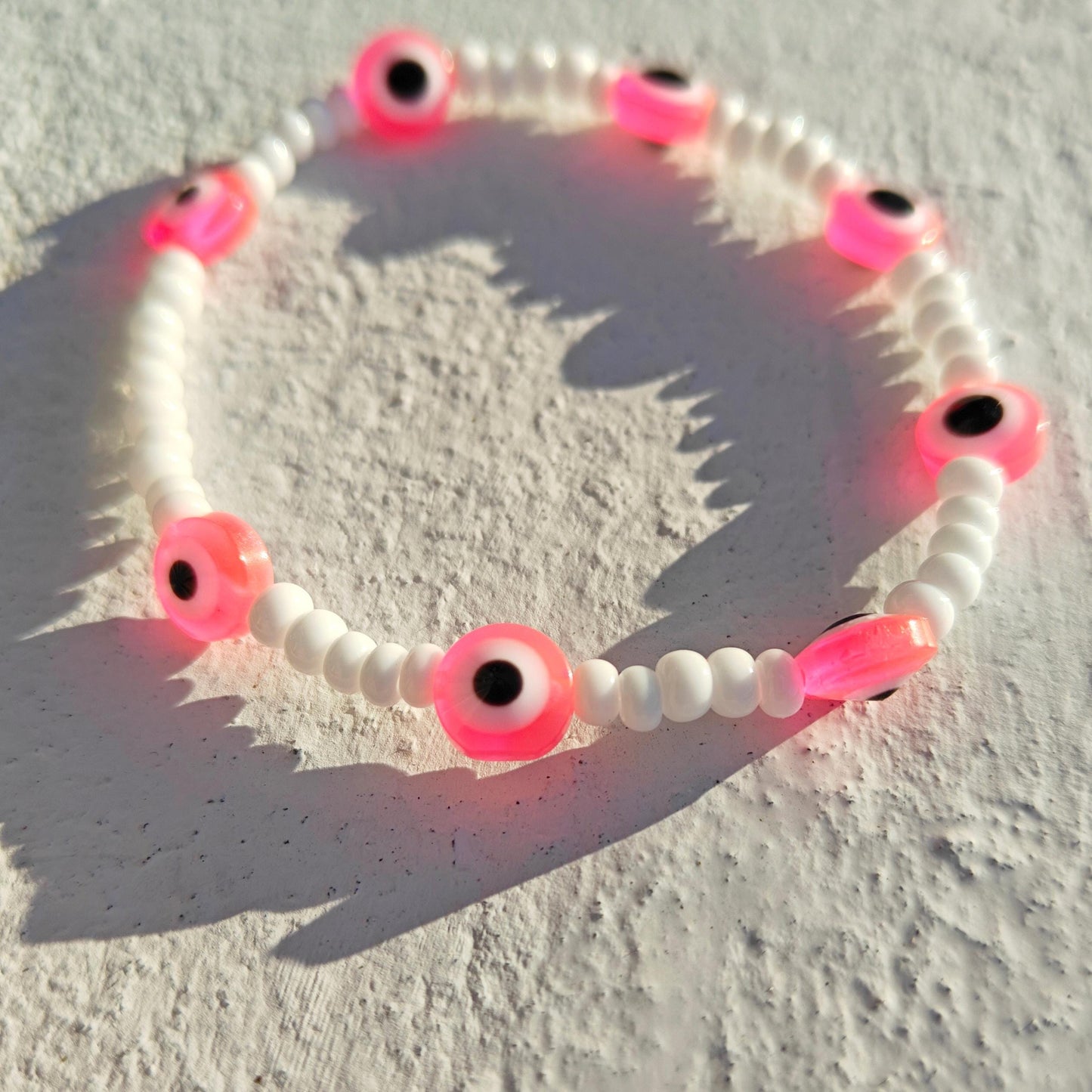 Evil eye inspired pink charm and seed bead bracelet