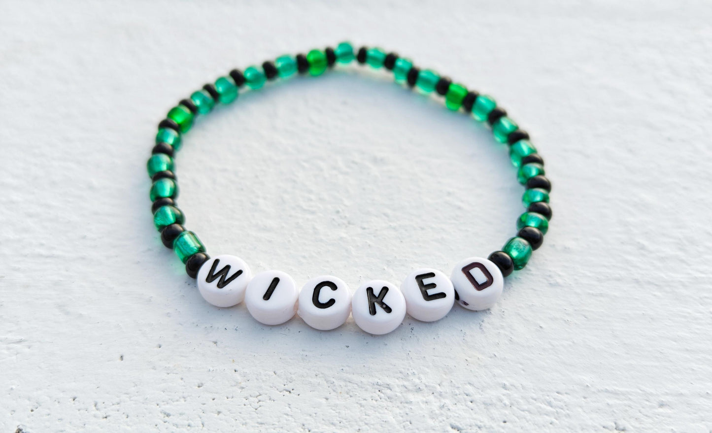 Wicked themed green and black seed bead bracelet on elastic string