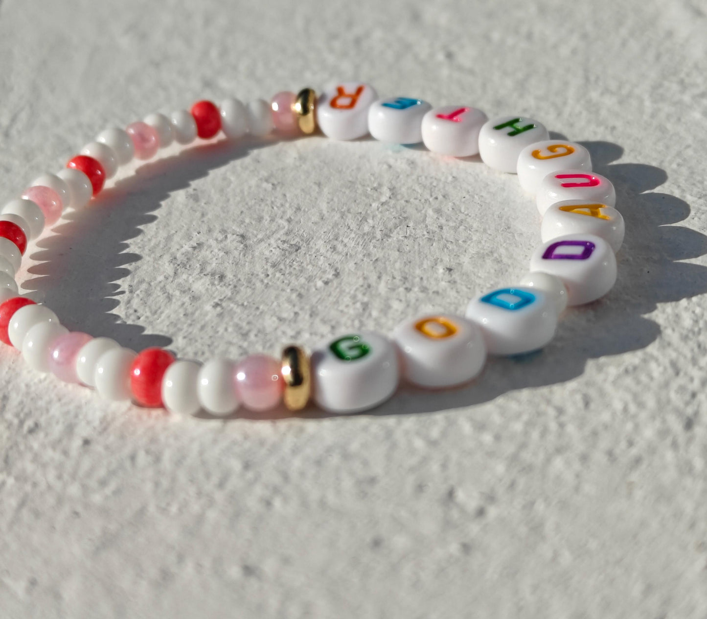 Colorful personalized name bead bracelet in pink white and gold with multicolored acrylic letter beads
