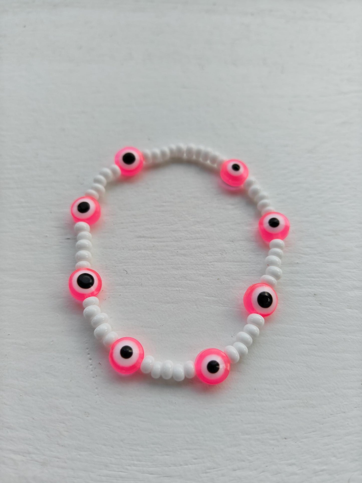 Evil eye inspired pink charm and seed bead bracelet