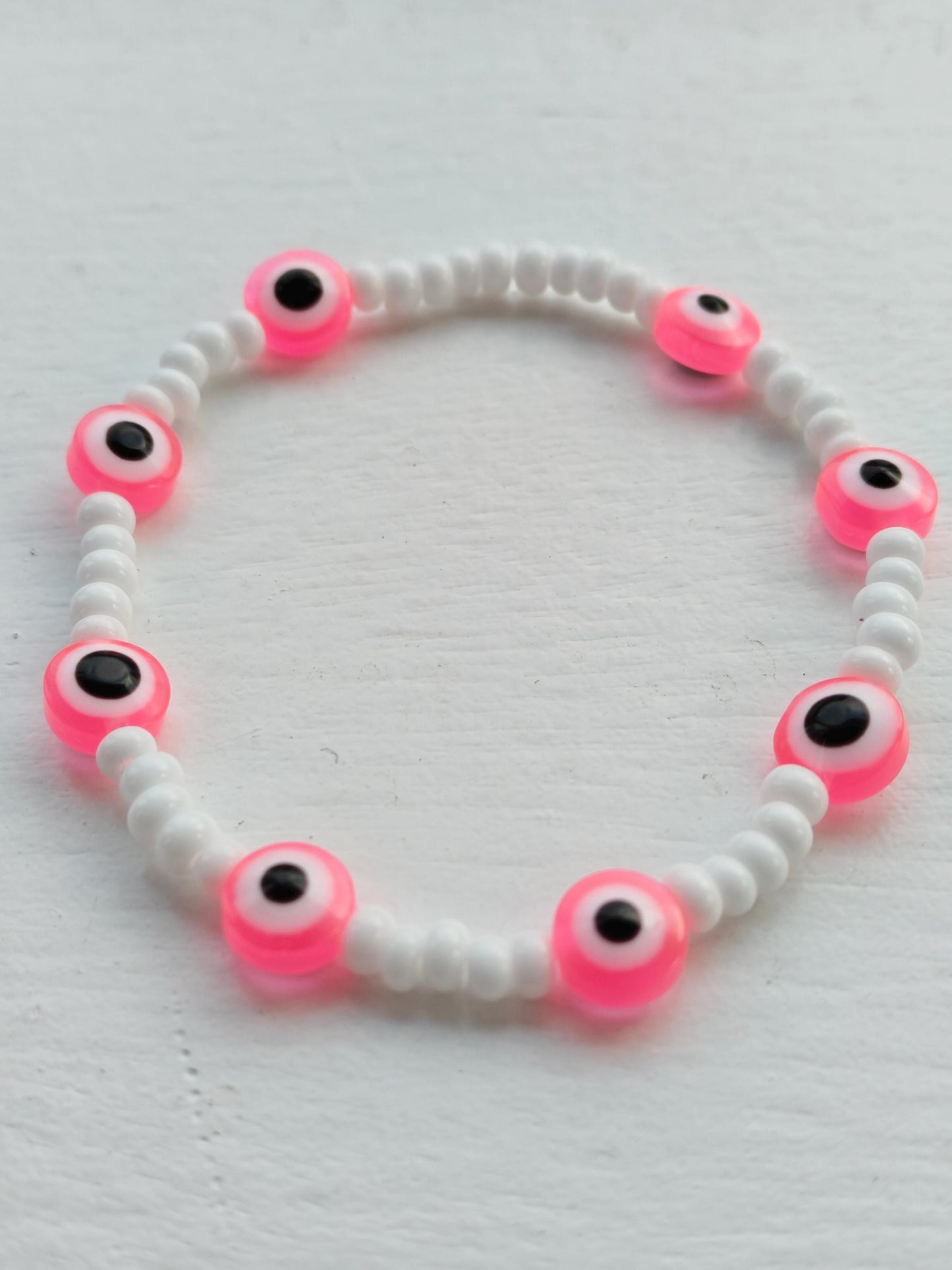 Evil eye inspired pink charm and seed bead bracelet